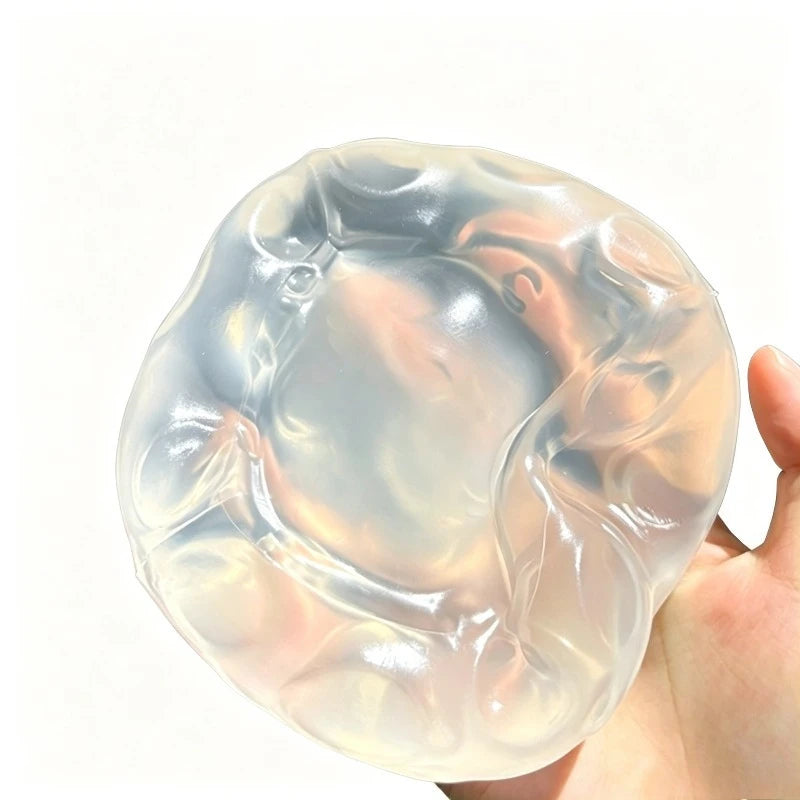 A translucent, squishy stress ball shaped like a coconut, being held in a hand.