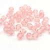 A pile of pink faceted bicone crystal glass beads for jewelry making.