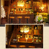 A detailed wooden dollhouse kit of a pink princess villa with illuminated LED lights displayed on a shelf.
