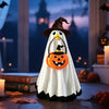 A white ghost costume with black trim and a pumpkin face is displayed in a dark, festive Halloween setting.