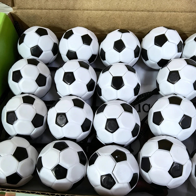 A collection of white and black magnetic soccer balls arranged in a cardboard box.