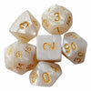 A set of seven polyhedral dice in translucent white and gold colors for tabletop gaming.