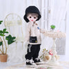 A doll dressed in a beige outfit and black hat standing next to a white pedestal table.