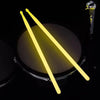 Pair of glow-in-the-dark nylon drumsticks casting a bright yellow light against a dark background.