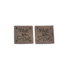 Two dark brown embossed leather labels with the text Made with Love engraved on them