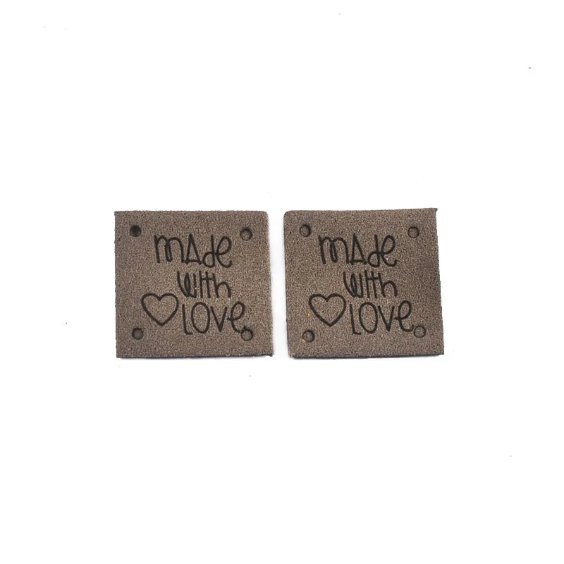 Two dark brown embossed leather labels with the text Made with Love engraved on them