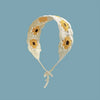A handmade crochet headband featuring yellow and orange daisy patterns on a cream-colored fabric.
