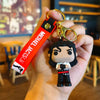 A keychain featuring a figurine of Michael Jackson in a dance pose with a red tag.