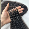 A woman models long, dark kinky straight crochet hair extensions with a natural texture.