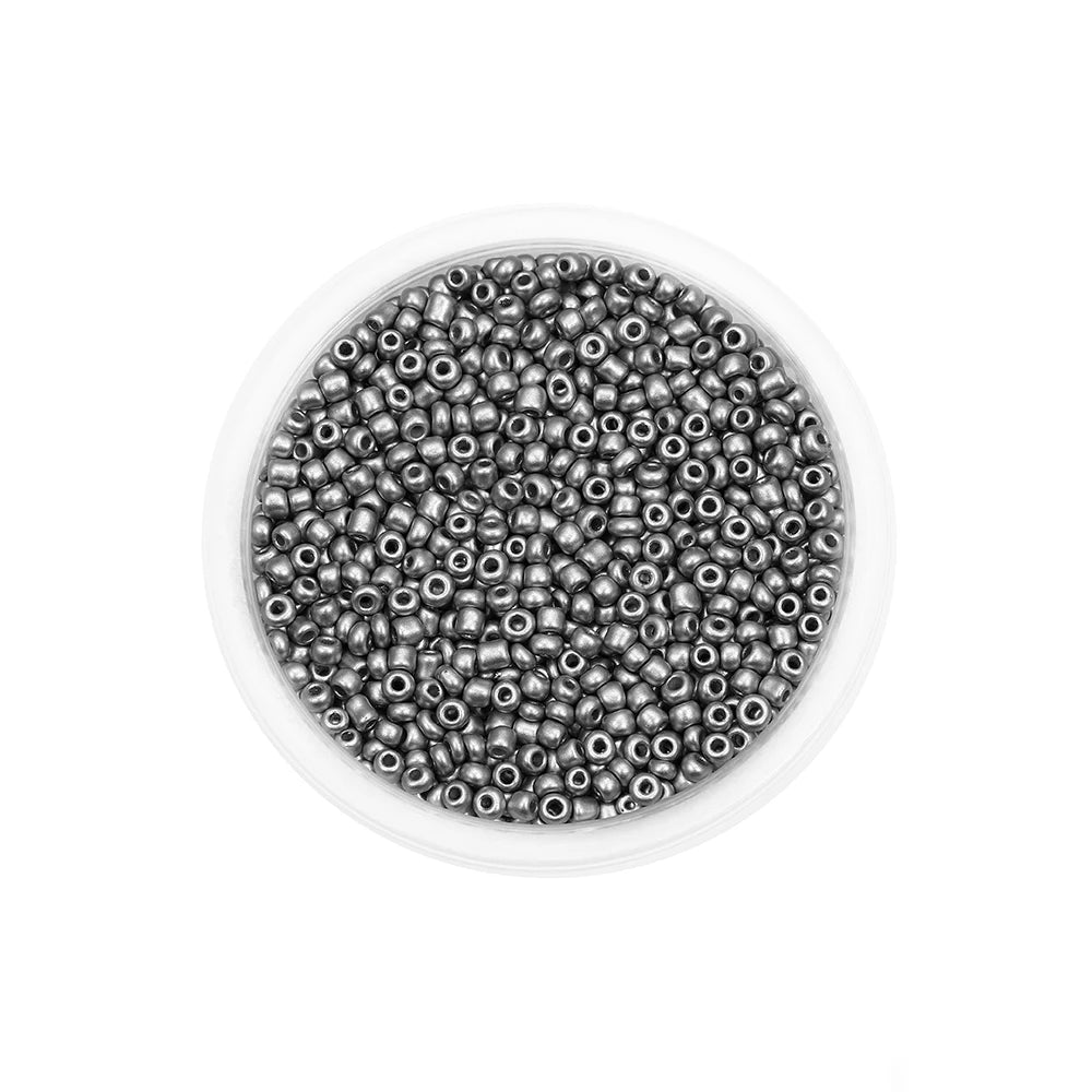 A clear container filled with small, round silver-colored glass seed beads for jewelry making.