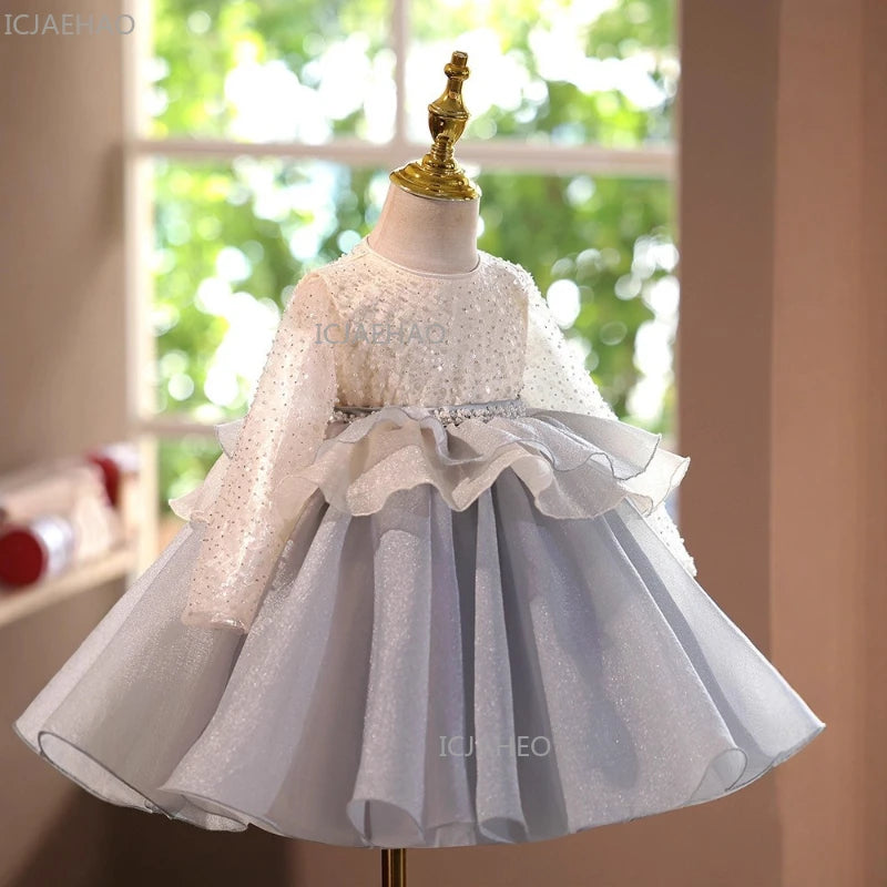 A white and light blue tulle dress displayed on a mannequin with gold accents.