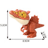 A small, reddish-orange finger dinosaur fidget toy with movable joints and a yellow eye.