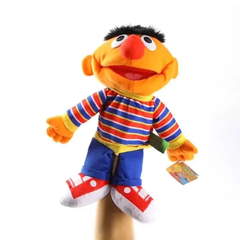 A large hand puppet plush toy resembling a smiling orange face with black hair and striped clothing.