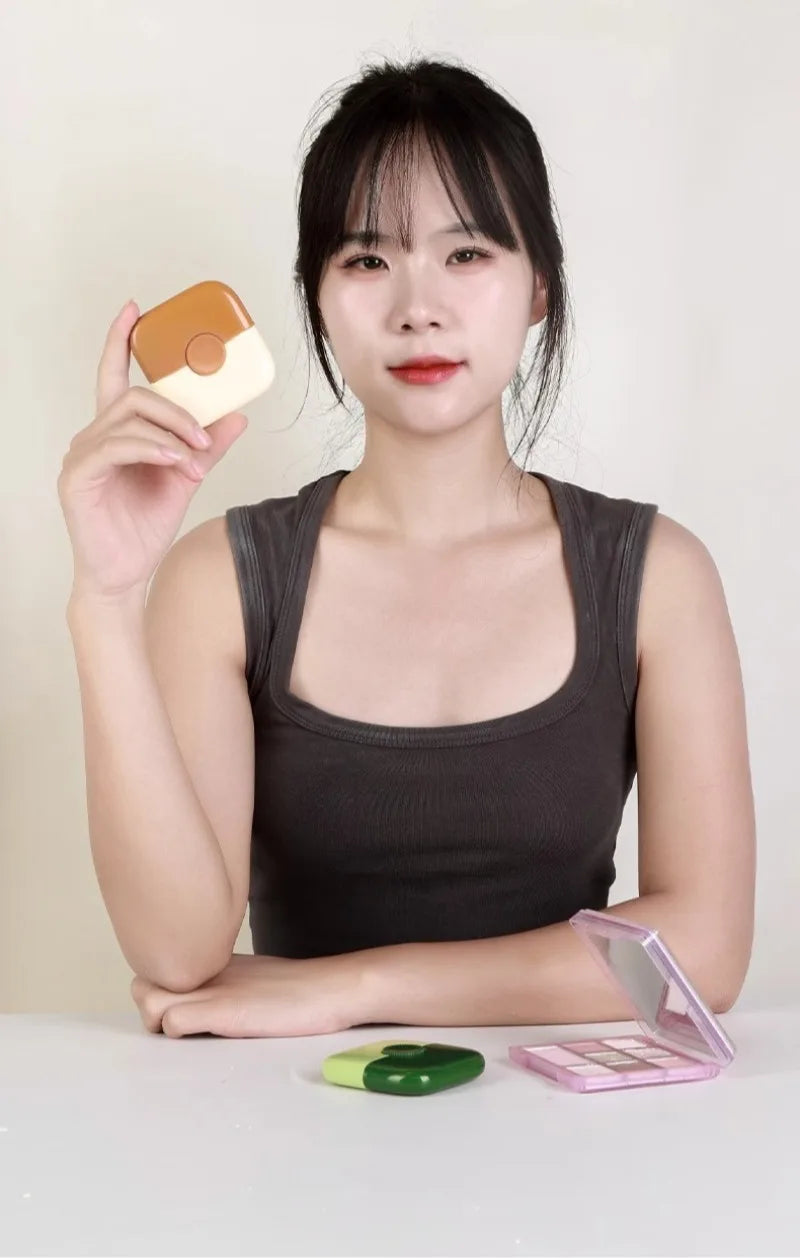 A woman holds a beige baby hair cutting comb with a dual-edge blade in her hand.