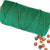 A spool of green natural cotton macrame rope for crafts and decor.