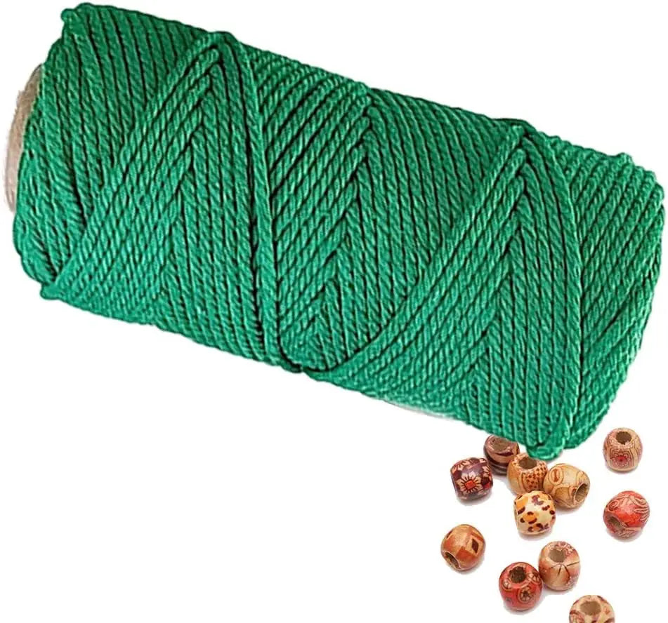 A spool of green natural cotton macrame rope for crafts and decor.