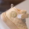 A light beige toddler winter snow boot with a quilted texture and a soft sole, featuring a loop closure.