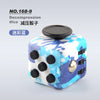 A white and blue marbled fidget cube with black dots and a gold button, featuring a rotating joystick.