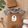 A brown baby bear print short sleeve romper and matching hat lying on a wooden surface.