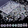 A collection of clear crystal glass beads and stones in various shapes and sizes, including a plastic container and loose bea
