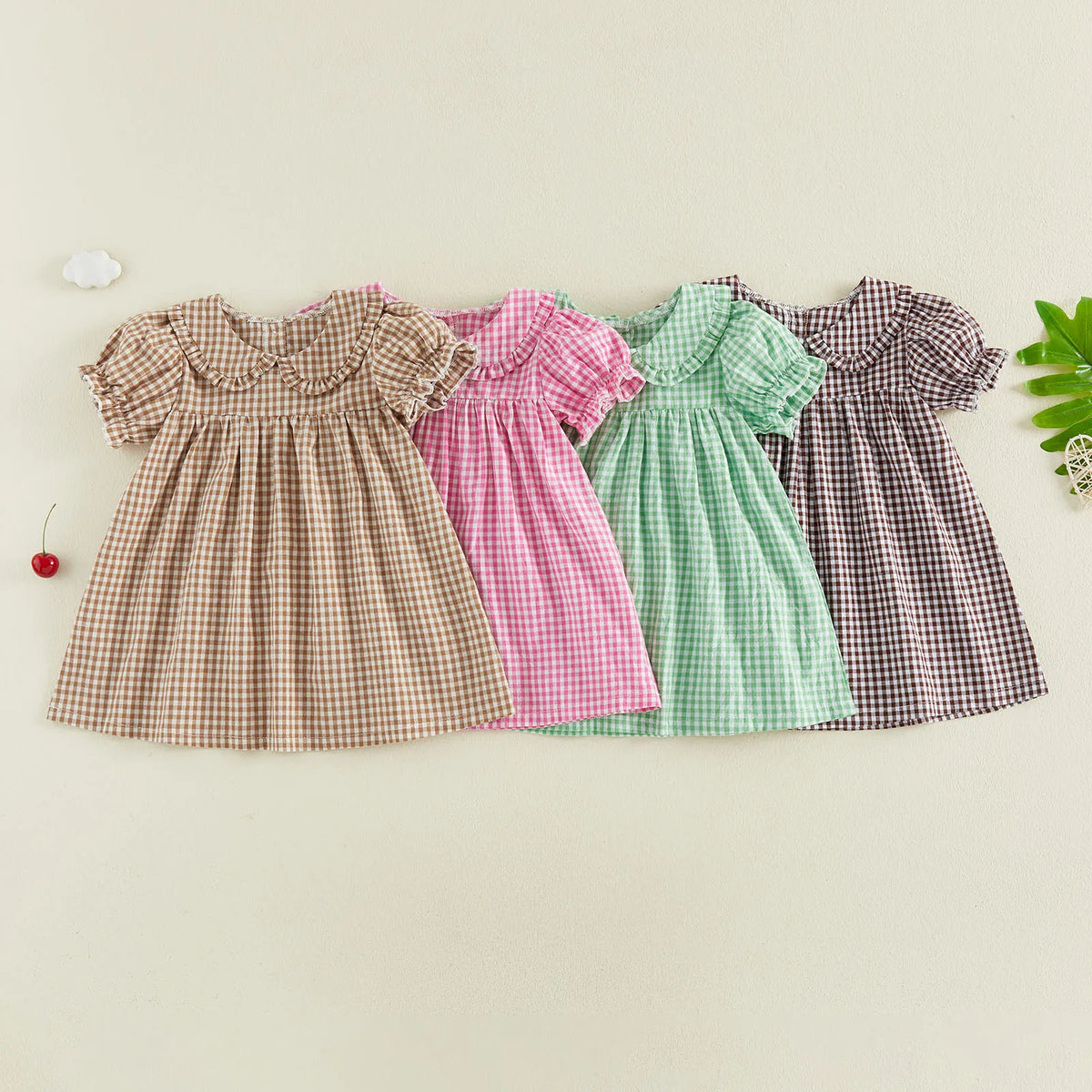 A row of plaid A-line dresses for toddlers in various colors including brown, pink, green, and purple.