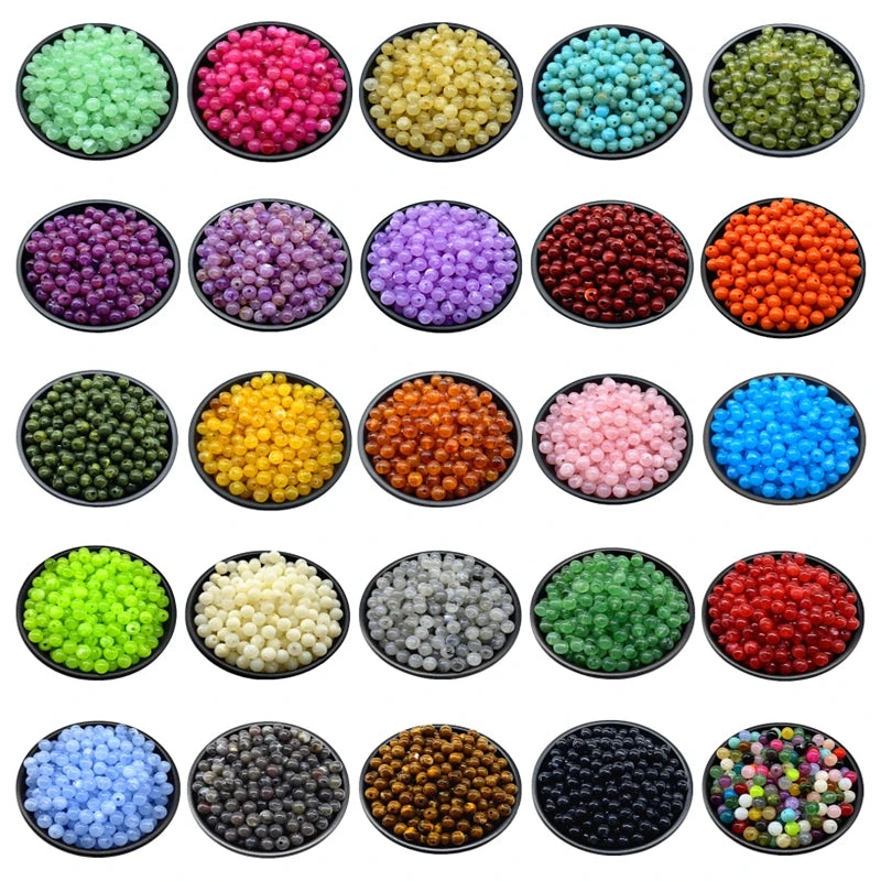 A collection of various colored acrylic round beads for jewelry making, displayed in small black bowls.