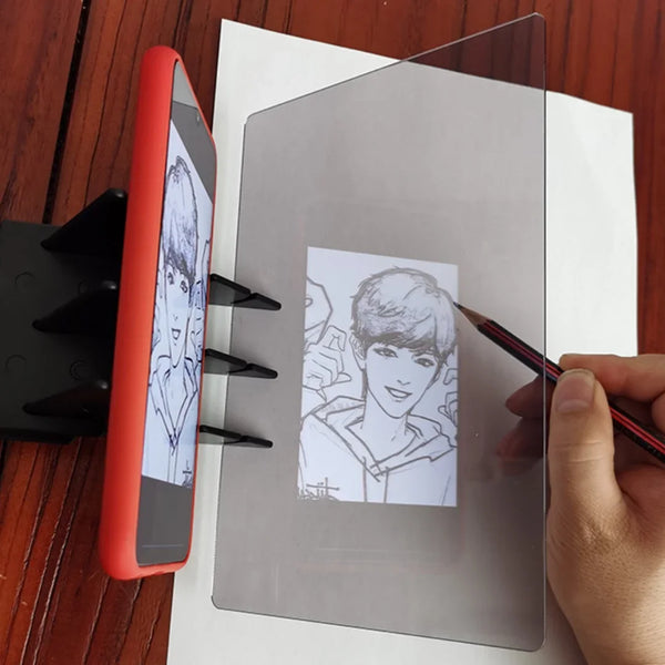 يد ترسم على لوح رسم شفاف بجوار جهاز محمول أحمر.