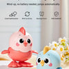 A pink and blue wind-up chick toy is shown on a wooden surface with surrounding text describing its features.