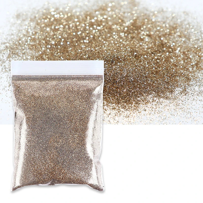A small bag of holographic fine glitter powder scattered next to a pile of the same glitter.