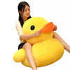 A young woman is holding a bright yellow plush toy shaped like a duck with an orange beak.