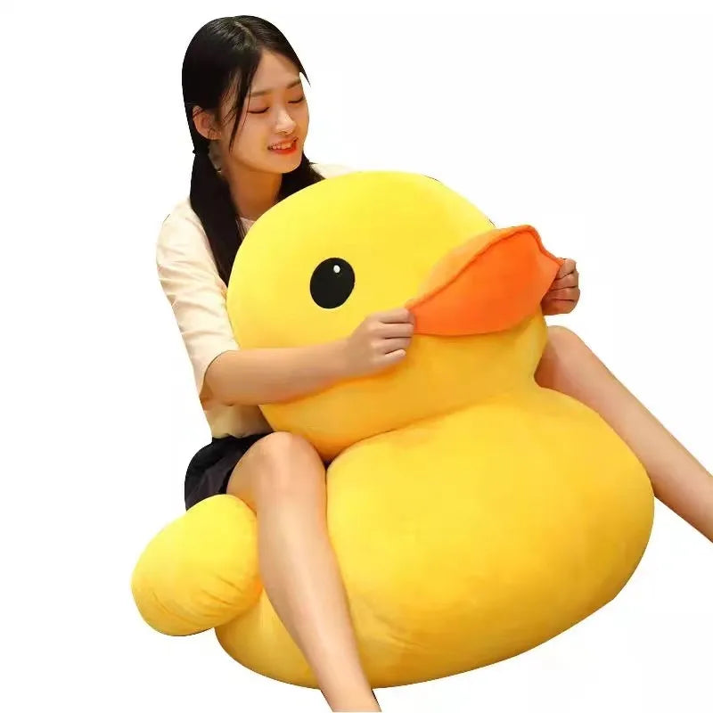 A young woman is holding a bright yellow plush toy shaped like a duck with an orange beak.