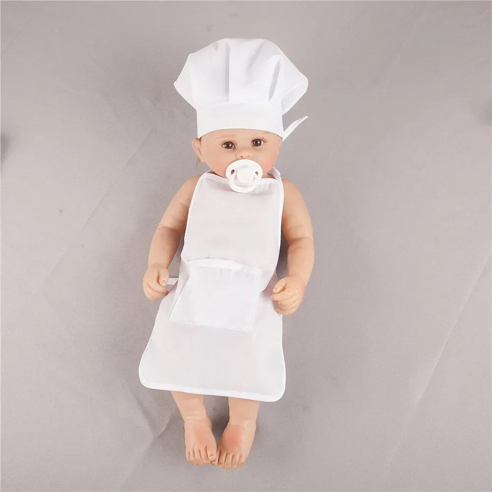 A baby doll dressed in a white chef hat and apron for pretend play