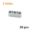 A white plastic piece with three circular holes, part of a 20-piece building block set.