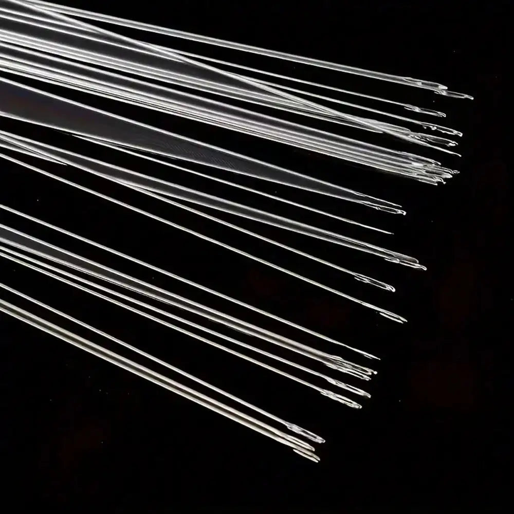 A collection of ultra-fine metal beading needles arranged diagonally on a dark surface.