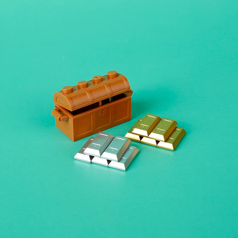 An open wooden treasure chest containing gold and silver building blocks on a teal background.