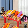 A red BBQ grill set filled with colorful toy food skewers and accessories for kids play