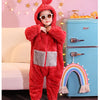 A child wearing a fuzzy red one-piece pajama costume with a hood and round glasses standing in front of a blue refrigerator.