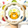 A hand drum and shake rattle set for toddlers is displayed in a decorative frame.