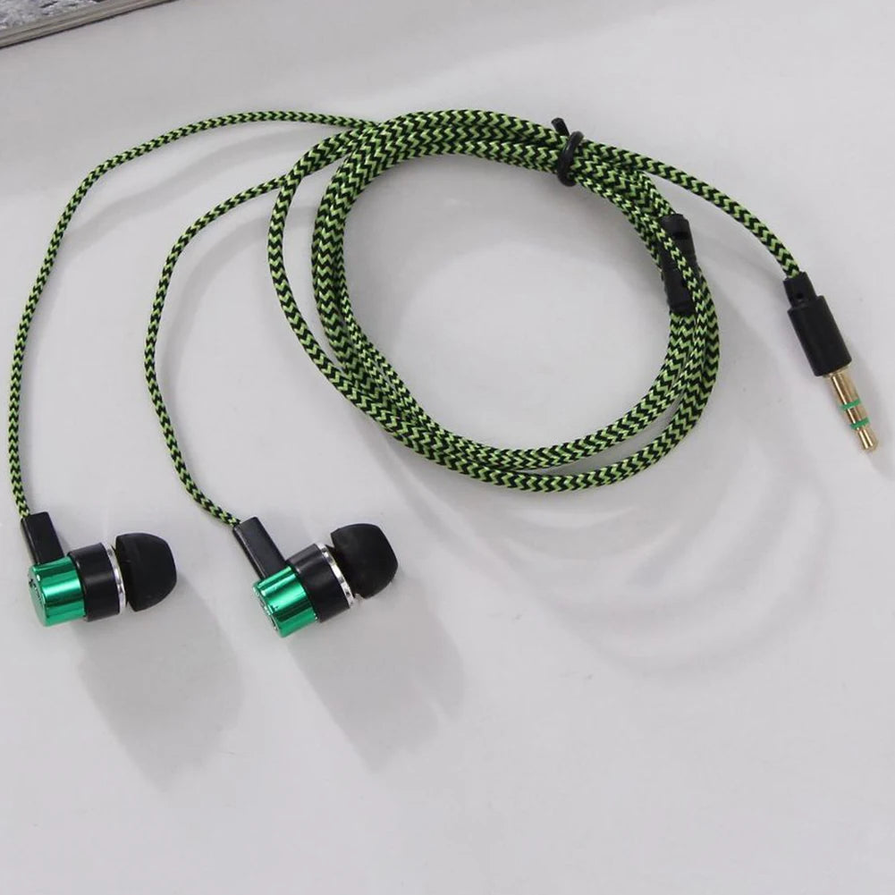 A black and green wired earbud set with a coiled cable and two earbuds resting on a white surface.
