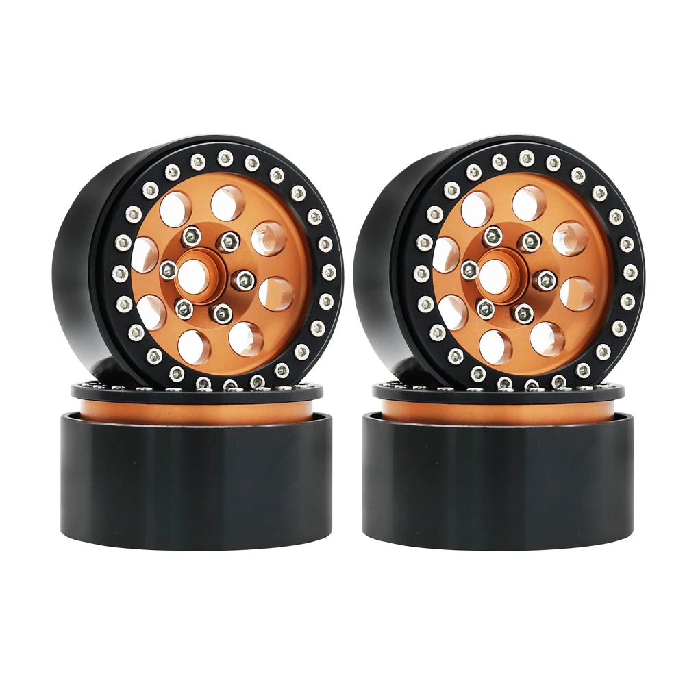 A pair of black metal beadlock wheels with a copper center and removable hex hub for an RC crawler.