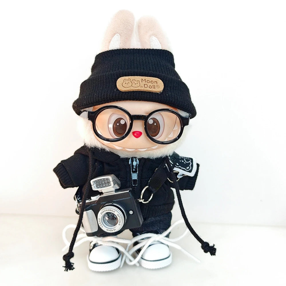 A Labubu doll wearing a black bear hoodie and headphones, with white laces on its feet.