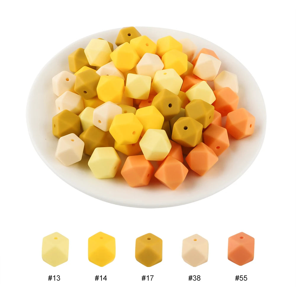 A plate of assorted yellow, orange, and white hexagonal silicone beads for DIY jewelry making