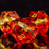 A close-up of a set of red resin dice with golden elven numbers, reflecting light against a dark background.