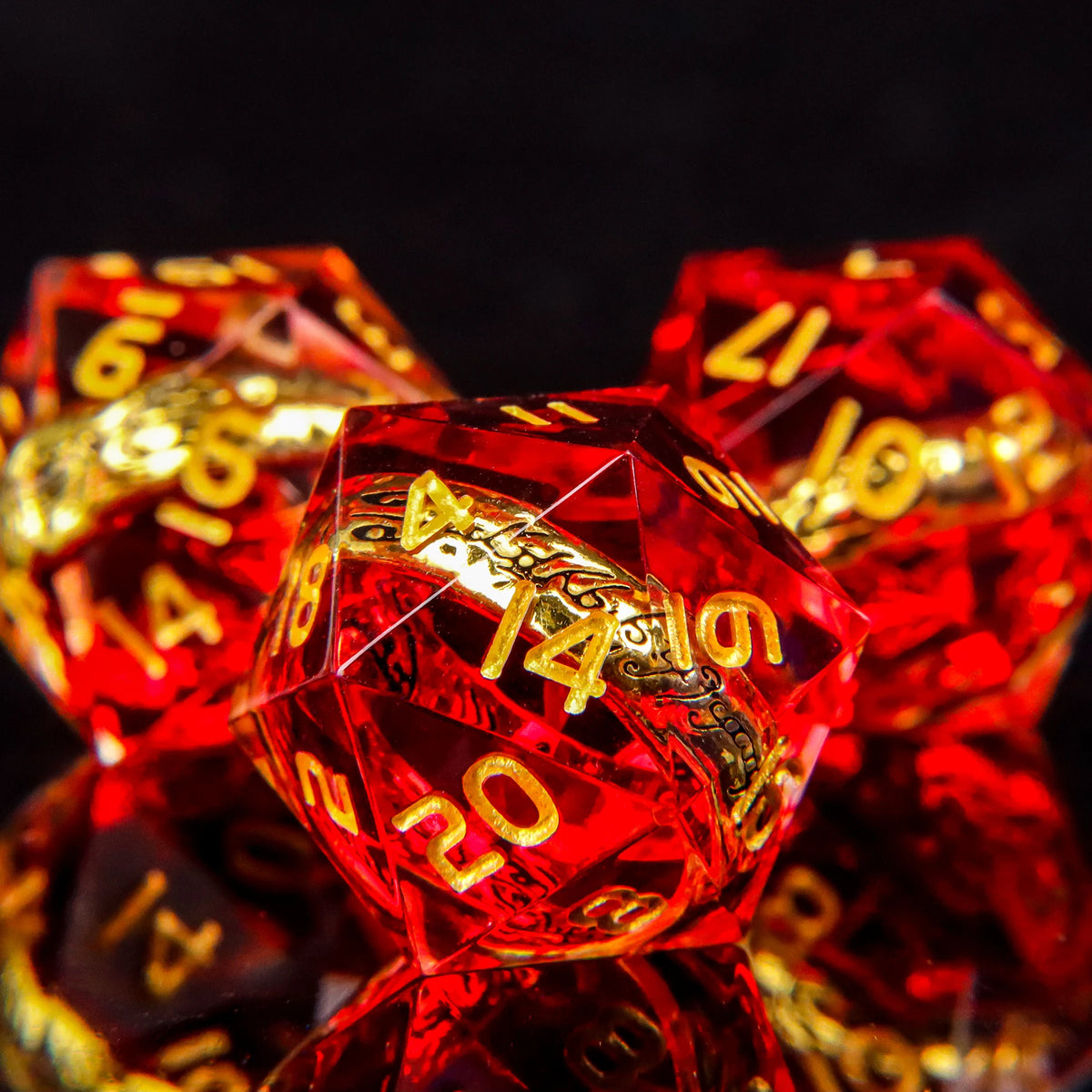 A close-up of a set of red resin dice with golden elven numbers, reflecting light against a dark background.