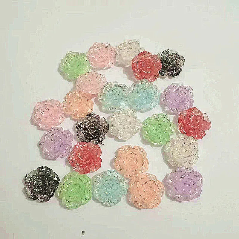 A collection of 20 pink, red, and green rose-shaped resin flowers in various shades arranged on a white background.