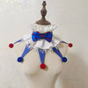 Handmade colorful clown ruff collar with blue and red accents displayed on a mannequin.