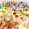 A collection of miniature dollhouse food items including cakes, wine bottles, and various snacks displayed on a hand.