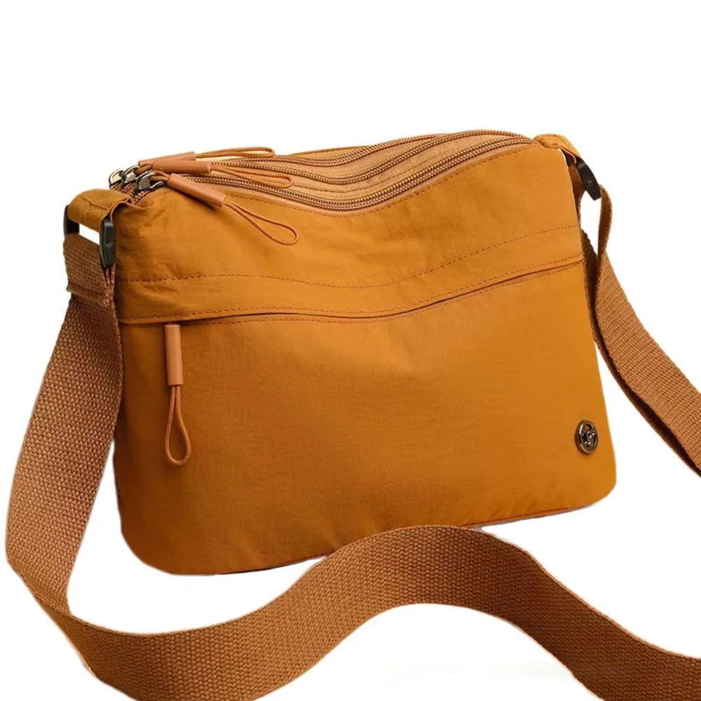 A tan canvas tote bag with multiple pockets and a brown strap is shown.
