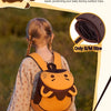 Un sac à dos orange pour enfant avec une sangle de sécurité porté par une jeune fille dehors.