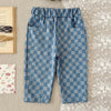 Blue and blue plaid corduroy pants with elastic waist for toddlers lying on a light fabric.